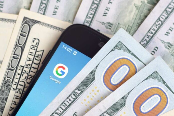 Smartphone with Google app on screen among US dollar bills