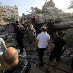 People search through rubble of a collapsed building