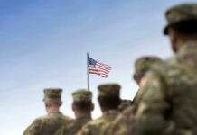VIDEO: Last U.S. Base Empties After 12 Years Soldiers in uniform facing American flag outdoors.