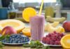 Berry smoothie in a glass with orange slice and straws