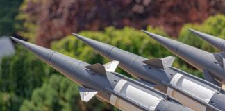 Close-up of multiple gray missiles with pointed noses and fins