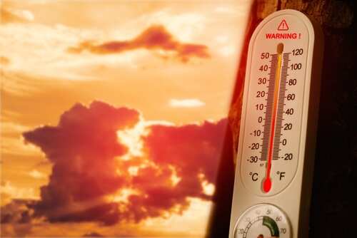 Thermometer displaying high temperature against a sunset background