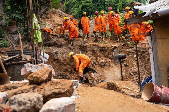 Rescue,Operations,By,The,Ndrf,Aided,By,Sniffer,Dogs,,Are Rescue workers in orange uniforms search a landslide site with a dog