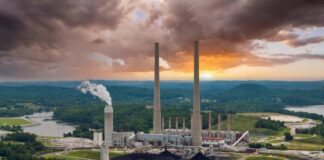 Coal-fired power plant with tall smokestacks at sunset