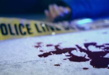 Workplace Rampage Inside Senior Home Blood on pavement with police tape and a hand in the background
