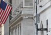 American flag outside a marble building on Wall Street