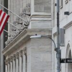 American flag outside a marble building on Wall Street