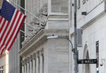 Wall Street Titans Applaud Trump Move American flag outside a marble building on Wall Street