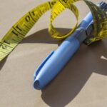 GLP-1 Wave Shakes Fast Food – DETAILS Blue pen with yellow measuring tape on a table