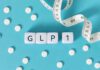 GLP-1 Linked to Sudden Blindness?! GLP-1 cubes with pills and a measuring tape on blue background