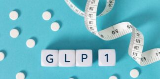 GLP-1 cubes with pills and a measuring tape on blue background