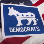 Dems Get Poll Shock Democrats emblem on an American flag background.