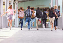Measles Comeback Risk: Exemptions Explode Children running with backpacks outside a school building.