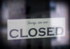 A sign hanging in a window that reads 'Sorry, we are CLOSED'