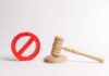 Wooden judge's gavel beside a red prohibition symbol