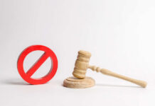 Wooden judge's gavel beside a red prohibition symbol