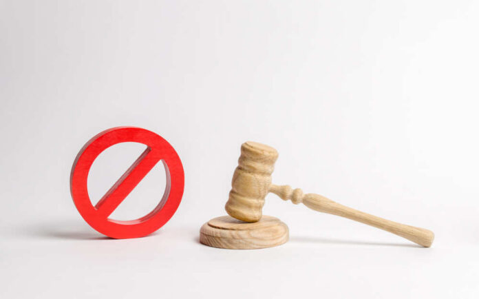 Judge's,Gavel,And,No,Symbol.,The,Concept,Of,Prohibiting,And Wooden judge's gavel beside a red prohibition symbol