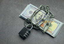 A stack of cash secured with a chain and padlock
