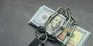 A stack of cash secured with a chain and padlock