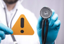 Insurance Giants Pull Plug on Seniors Doctor with stethoscope holding a warning sign