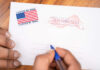 Election Gamble Hits Wall Hands addressing an official election mail envelope