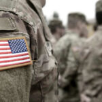 Soldiers in camouflage uniforms with American flag patches.