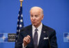 Biden Aide Caught By FBI?! Joe Biden speaking at a podium with a blue NATO backdrop
