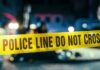 VIDEO: Mom, Baby Plunge Police line caution tape at a crime scene with blurred figures in the background