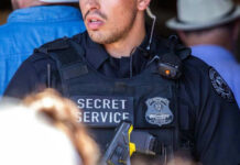 Secret Service officer in tactical vest with radio and badge