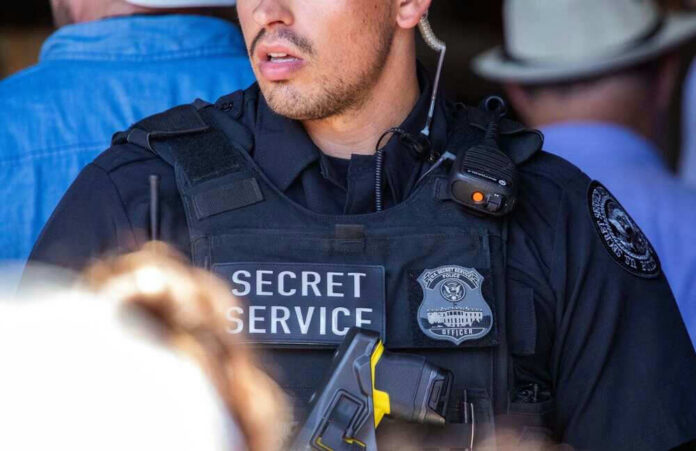 Secret Service officer in tactical vest with radio and badge