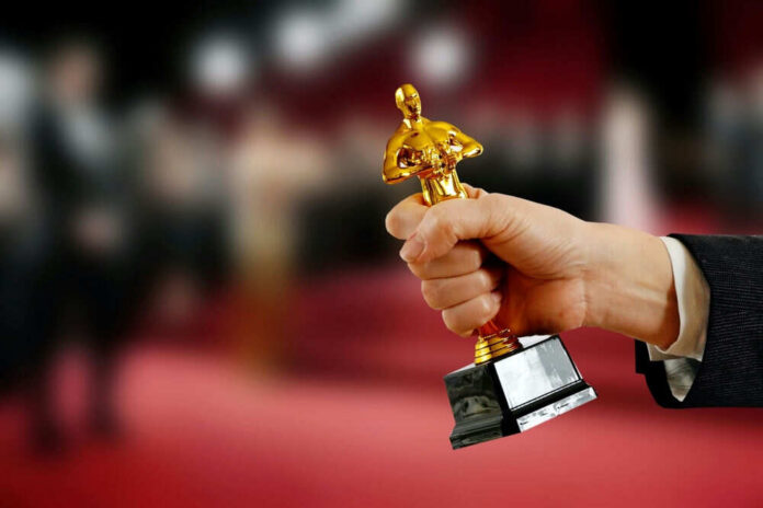Hand holding an Oscar award