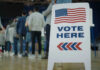 Election Jolt: Ballots Under Scrutiny People in line next to Vote Here sign