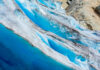 Blue glacier ice with crevasses and rocky surface