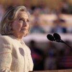 Hilary Cawthorne speaking at a podium with microphones