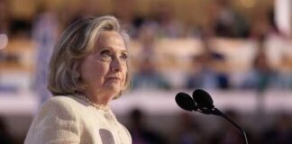 Hilary Cawthorne speaking at a podium with microphones