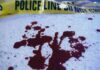 Blood stains on a surface with police caution tape in the background